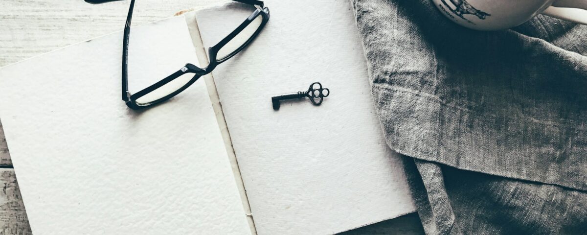 eyeglasses and skeleton key on white book