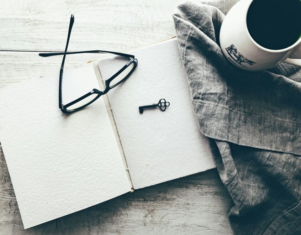 eyeglasses and skeleton key on white book